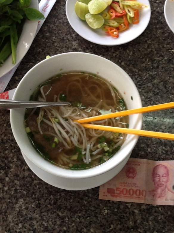 Pictured: a bowl of pho soup and a $2.5 bill.